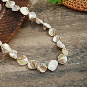 Macro detail of natural irregular shell beads necklace with iridescent luster and texture
