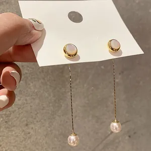 Close-up of bohemian gold plated long tassel earrings with pearls on display card