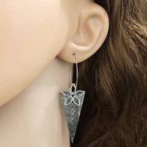 Detail von Edelstahl-Ohrring mit Muschel-Anhänger und geometrischem Blumen-Metall-Design