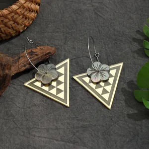 Detailansicht der Dreieckohrringe mit schwarzen geometrischen Muscheleinlagen und Blumendetail