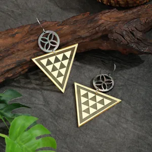 Details von goldenen geometrischen Ohrringen mit Muscheleinlage auf grauem Leinen