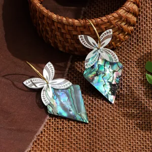 Makroaufnahme von Boho-Ohrringen mit Abalone-Muschel und strukturierten Metallblättern