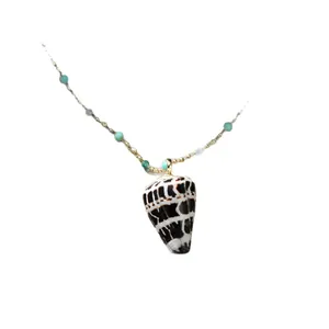 Collier avec pendentif coquillage naturel et perles vertes sur fond blanc