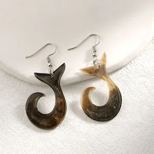 Détail des boucles d'oreilles crochet queue de baleine avec gravures tribales et nacre