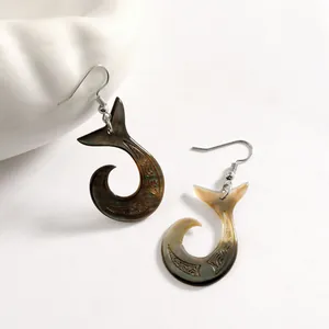 Boucles d'oreilles Makau en nacre de style polynésien avec gravures sur fond blanc