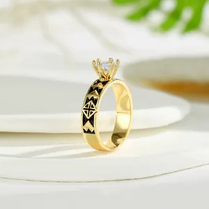 Dettaglio macro di un anello vintage dorato con zircone e motivi geometrici in smalto nero