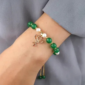 Detailed shot of green jade and pearl bracelet with adjustable gold leaf charm