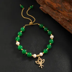 Detail of green jade beads and natural pearls on adjustable gold-plated bracelet