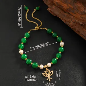 Detail of beaded bracelet with green stones, pearls and a golden leaf charm