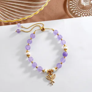 Détail du bracelet en perles d'améthyste et nacre avec chaîne dorée réglable et pendentif