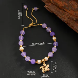 Gros plan d'un bracelet en améthyste et perles avec pendentif fleur dorée et mesures