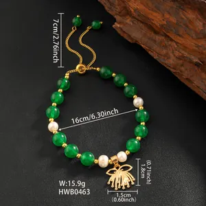 Detail of green jade beads and natural pearls on an adjustable gold bracelet with flower charm