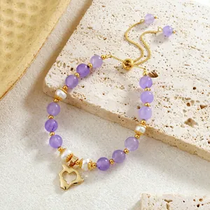 Détail du bracelet en améthyste et perles avec un pendentif en forme de cœur doré
