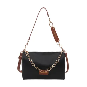 Stylish black shoulder bag with brown strap and gold flower chain decoration for women