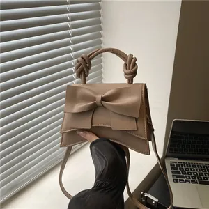 Minimalist khaki bow underarm bag with knotted handle and elegant asymmetric design