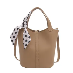 Sac seau en cuir grainé marron avec poignée et foulard décoratif à pois blancs
