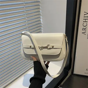 Chic off-white leather shoulder bag with gold horsebit buckle in a minimalist setting