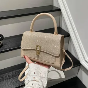 Champagnergoldene Strass-Handtasche mit cremefarbenem Lederriemen auf Stufen