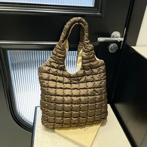 Deep brown quilted tote bag with soft padded texture on a modern marble table