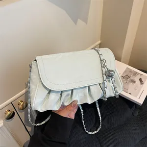Light blue ruched crossbody bag with silver chain strap and metallic orb charm detail