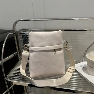 Elegant off-white lychee grain shoulder bag with wide strap and gold hardware accents