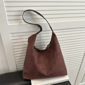 Minimalist large dark brown hobo shoulder bag in premium suede leather against white shutters