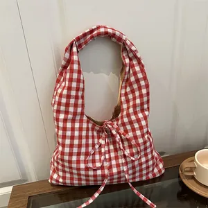 Classic red and white gingham tote bag with bow detail on a rustic wooden table