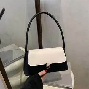 Sac à bandoulière minimaliste chic noir et blanc avec détails dorés pour le look 2025