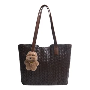 Retro dark brown woven leather tote bag with shoulder straps and plush dog charm