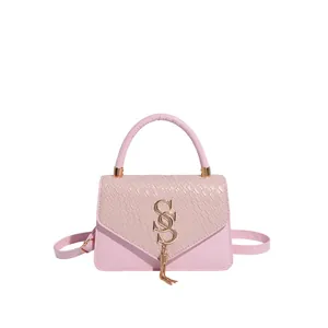 Pink patchwork crossbody bag with crocodile texture, gold logo and stylish tassel detail