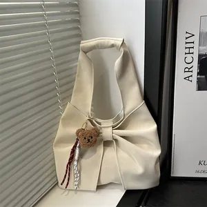 Chic cream tote bag with large bow design and plush bear charm for daily commuting