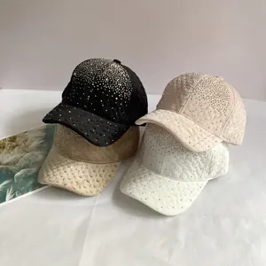 Détail de quatre casquettes en velours avec strass et motif de losanges matelassés