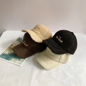 Close-up of winter sherpa baseball caps in black, brown, and cream with POZZID embroidery