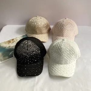 Détail de quatre casquettes de baseball en velours avec strass brillants en noir et rose