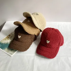 Nahaufnahme von vier Fleece-Baseballkappen mit besticktem M-Buchstaben-Bären-Aufnäher