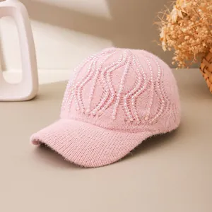 Detail view of pink knitted baseball cap featuring iridescent beads and sequins decorations