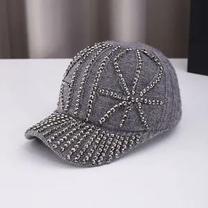 Close-up of dark grey knitted baseball cap featuring silver stud geometric patterns