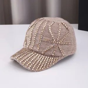 Detailed close-up of khaki knit baseball cap featuring glittering gold rhinestone patterns