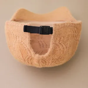 Detail of adjustable black buckle and knit texture on the back of the beige beanie cap