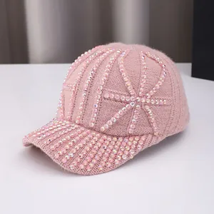 Close-up of pink knit baseball cap with sparkling rhinestones and warm winter texture