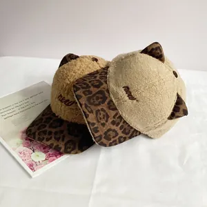 Detailed view of beige plush baseball cap with leopard cat ears and embroidery