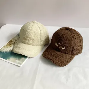 Detail of warm lamb wool baseball caps with FOZZIO embroidery in white and brown