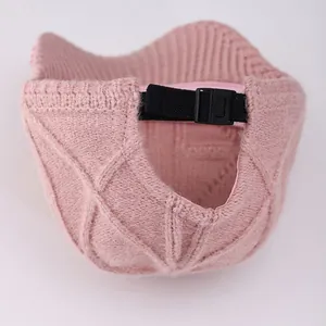 Detail of pink knitted baseball cap with adjustable black strap and plastic buckle closure