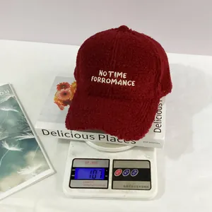 Macro view of burgundy sherpa baseball cap on a digital scale weighing 107 grams