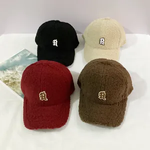 Detailed flat lay of lamb velvet baseball caps in black, cream, red, and brown with R logo