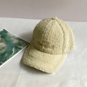 Close-up of cream faux shearling baseball cap with New York embroidery on white background