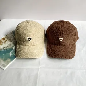 Detailstruktur der Fleece-Baseballkappen in Beige und Braun mit Bären-M-Patch