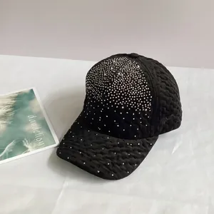 Détail de la casquette de baseball en velours noir avec texture gaufrée et strass argentés
