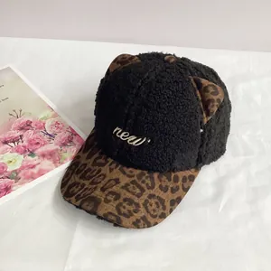 Detailed macro view of soft black fleece texture with leopard print cat ears and gold embroidery