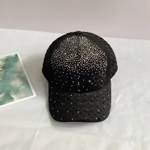 Vue détaillée d'une casquette en velours noir ornée de strass brillants et texture matelassée